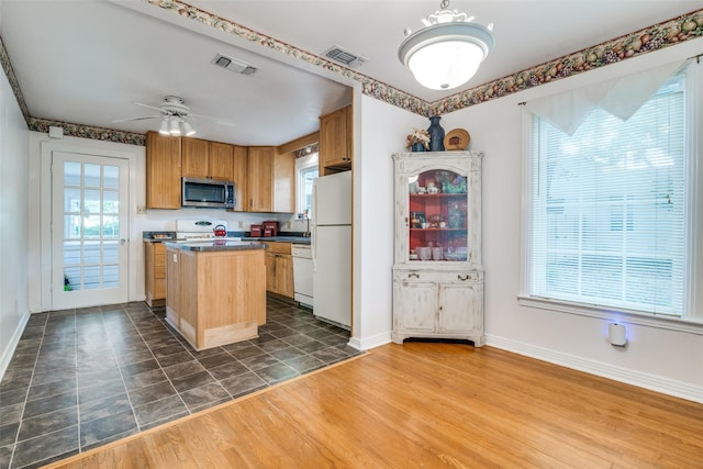 1312 Linden Ln, Garland, TX 75040 - kitchen with white appliances, a kitchen island, dark countertops, ceiling fan, and dark wood-type flooring