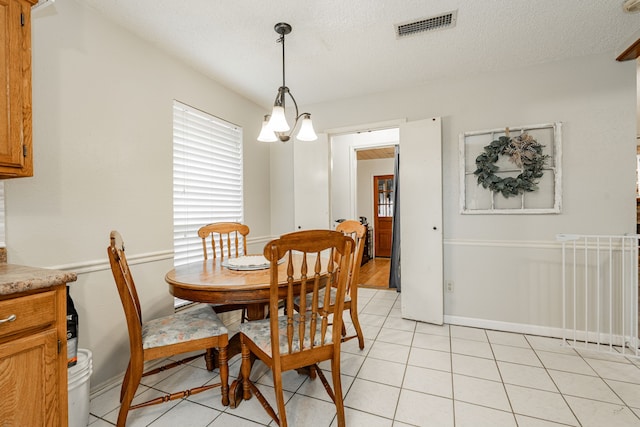 3615 7th St, Sachse, TX 75048 - dining room with light tile patterned flooring and a textured ceiling