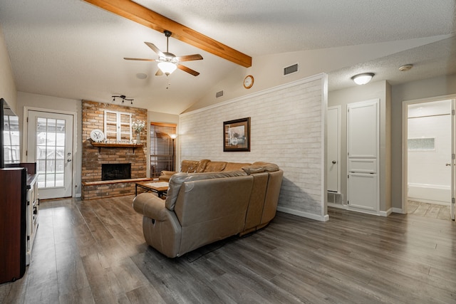 3615 7th St, Sachse, TX 75048 - living room with ceiling fan, a brick fireplace, dark wood-style floors, brick wall, and a textured ceiling