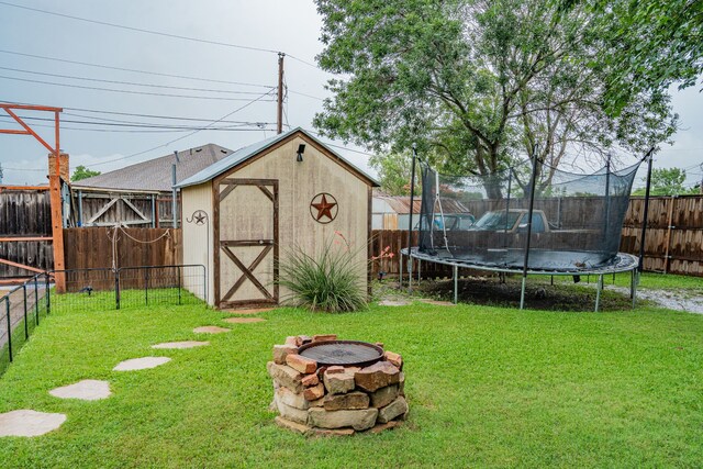 3615 7th St, Sachse, TX 75048 - fenced backyard featuring a trampoline, an outdoor fire pit, and a storage shed