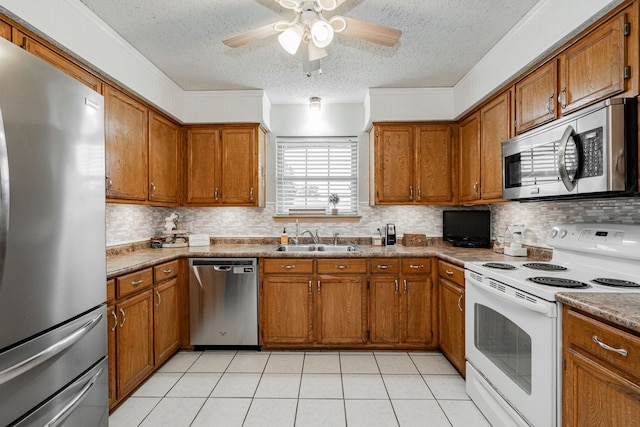 3615 7th St, Sachse, TX 75048 - kitchen with appliances with stainless steel finishes, a textured ceiling, brown cabinets, and backsplash