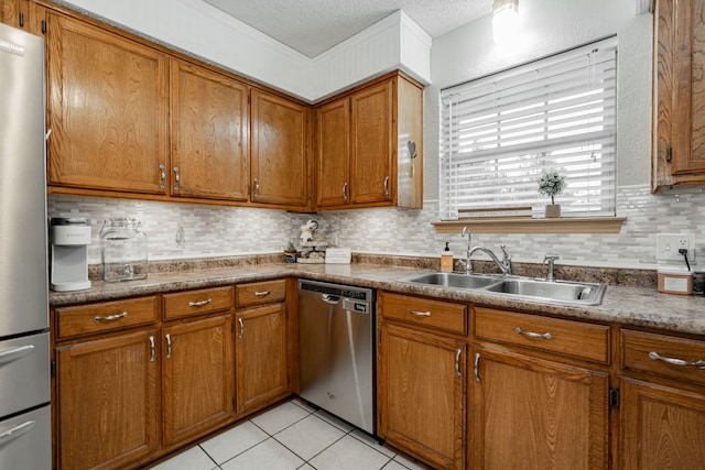 3615 7th St, Sachse, TX 75048 - kitchen featuring appliances with stainless steel finishes, brown cabinetry, decorative backsplash, and a textured ceiling