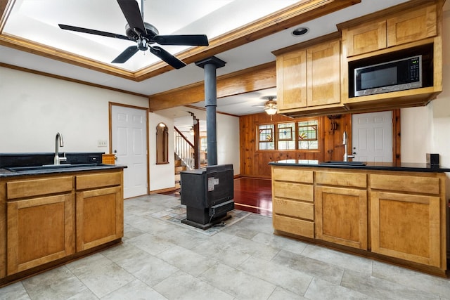 1933 E Hickory Hill Rd, Argyle, TX 76226 - kitchen with stainless steel microwave, a wood stove, a ceiling fan, dark countertops, and crown molding