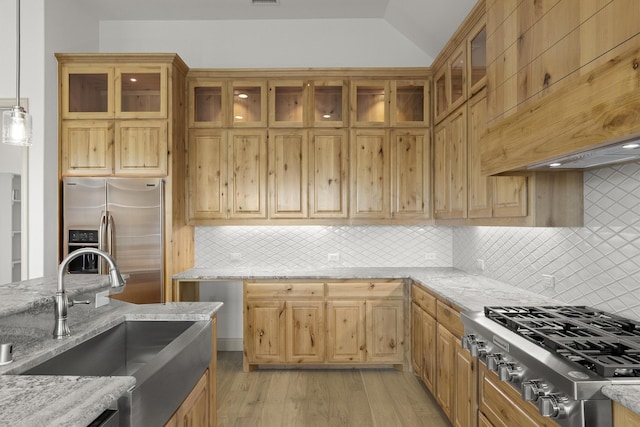 3148 Bryne Ln, Rockwall, TX 75087 - kitchen featuring stainless steel appliances, custom range hood, light wood-style flooring, light stone counters, and vaulted ceiling