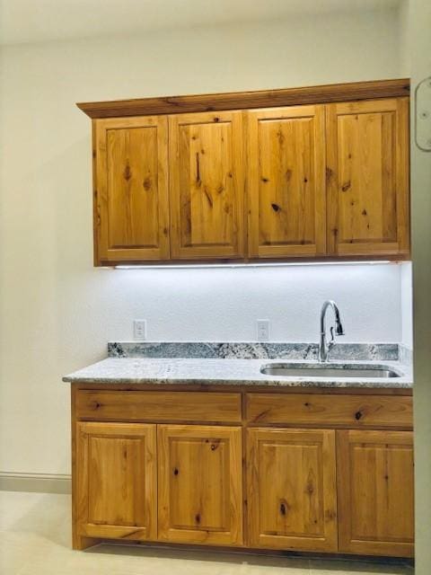 3148 Bryne Ln, Rockwall, TX 75087 - kitchen featuring brown cabinetry and light stone countertops