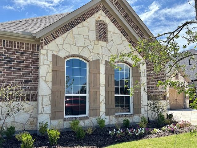3148 Bryne Ln, Rockwall, TX 75087 - view of property exterior featuring stone siding, concrete driveway, brick siding, and a shingled roof