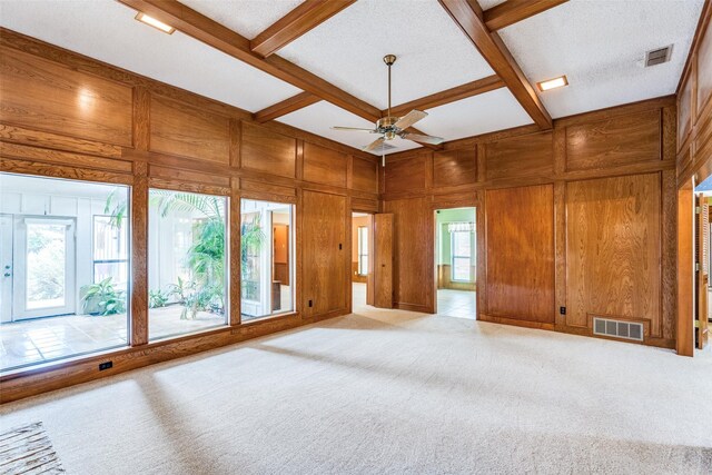 3404 Appalachian Way, Plano, TX 75075 - unfurnished living room with carpet floors, wood walls, ceiling fan, built in shelves, and beamed ceiling