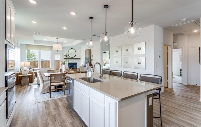 11208 Orchard Ln, Justin, TX 76247 - kitchen featuring open floor plan, appliances with stainless steel finishes, a glass covered fireplace, light wood finished floors, and recessed lighting