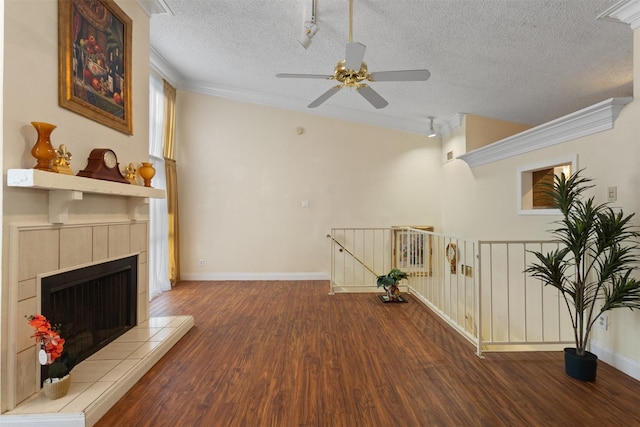 6503 Ridgecrest Rd Unit 107G, Dallas, TX 75231 - living area with ceiling fan, a textured ceiling, wood finished floors, track lighting, and a tiled fireplace