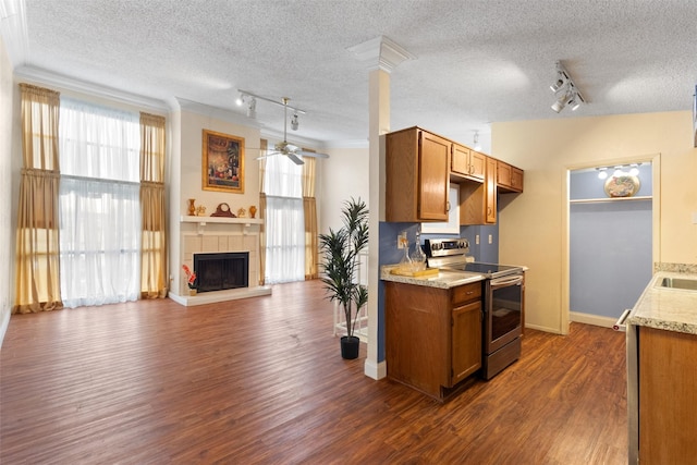 6503 Ridgecrest Rd Unit 107G, Dallas, TX 75231 - kitchen with stainless steel range with electric stovetop, track lighting, a textured ceiling, brown cabinetry, and ornamental molding