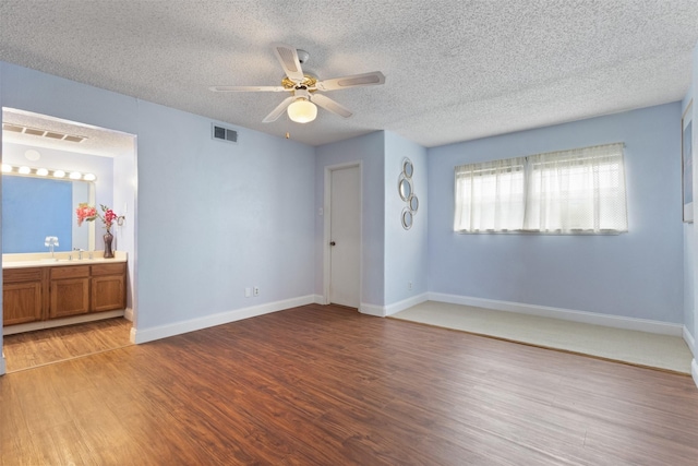 6503 Ridgecrest Rd Unit 107G, Dallas, TX 75231 - empty room with a textured ceiling, wood finished floors, and ceiling fan