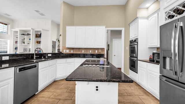 6740 Magnum Dr, Plano, TX 75024 - kitchen with appliances with stainless steel finishes, dark stone countertops, white cabinets, and light tile patterned floors