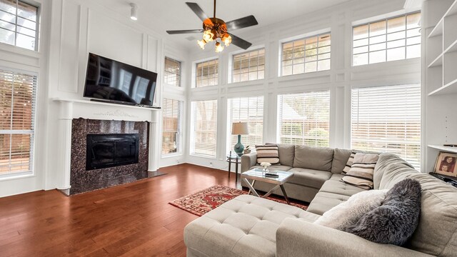 6740 Magnum Dr, Plano, TX 75024 - living room with ceiling fan, a premium fireplace, dark wood-style flooring, healthy amount of natural light, and a high ceiling