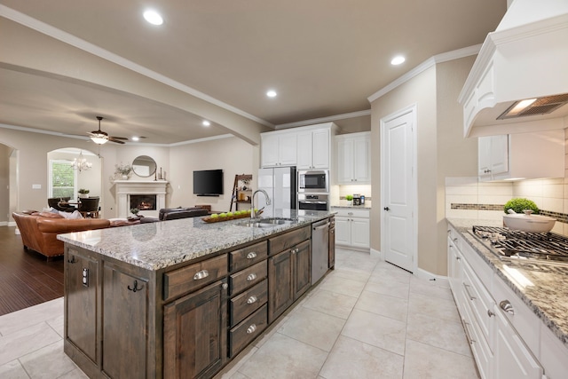 8240 Odell St, North Richland Hills, TX 76182 - kitchen featuring appliances with stainless steel finishes, arched walkways, white cabinets, custom exhaust hood, and recessed lighting