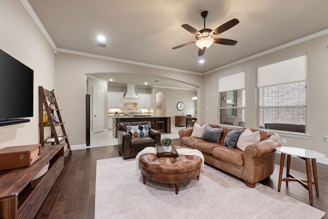 8240 Odell St, North Richland Hills, TX 76182 - living area with arched walkways, crown molding, a ceiling fan, dark wood finished floors, and recessed lighting