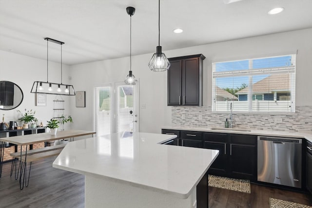 9009 Benevolent Ct, Providence Village, TX 76227 - kitchen with stainless steel dishwasher, light countertops, dark wood finished floors, tasteful backsplash, and decorative light fixtures
