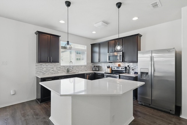 9009 Benevolent Ct, Providence Village, TX 76227 - kitchen featuring stainless steel appliances, decorative backsplash, dark wood-style floors, a kitchen island, and recessed lighting