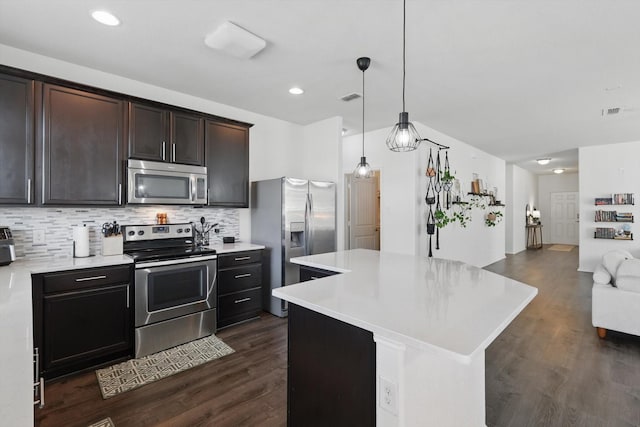 9009 Benevolent Ct, Providence Village, TX 76227 - kitchen with appliances with stainless steel finishes, light countertops, decorative backsplash, dark brown cabinets, and open floor plan