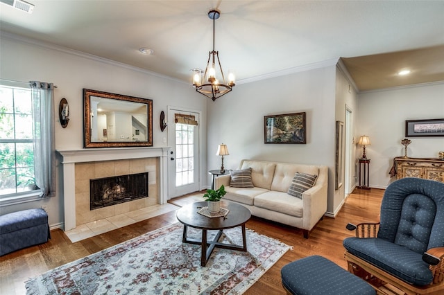 17342 Remington Park Pl, Dallas, TX 75252 - living area with crown molding, a chandelier, wood finished floors, a tiled fireplace, and recessed lighting