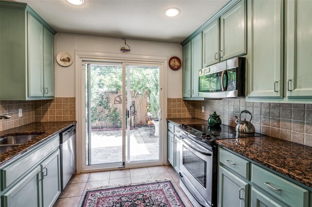 17342 Remington Park Pl, Dallas, TX 75252 - kitchen with green cabinets, appliances with stainless steel finishes, dark stone countertops, light tile patterned flooring, and recessed lighting