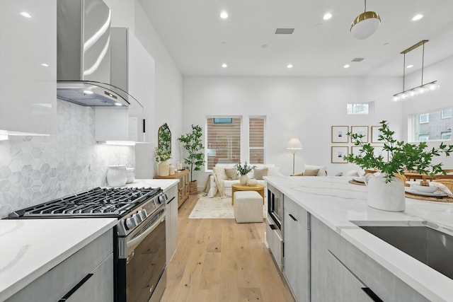 4208 Live Oak St Unit 102, Dallas, TX 75204 - kitchen with stainless steel appliances, wall chimney exhaust hood, modern cabinets, recessed lighting, and light wood-type flooring
