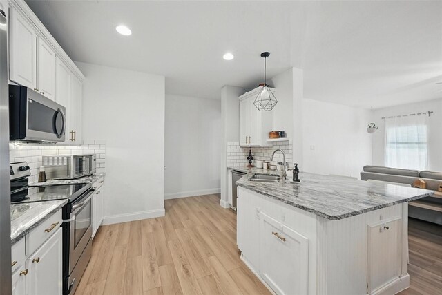 1828 Brown Thrasher Blvd, Savannah, TX 76227 - kitchen with stainless steel appliances, backsplash, white cabinets, light wood-type flooring, and light stone counters