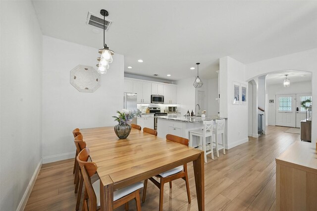 1828 Brown Thrasher Blvd, Savannah, TX 76227 - dining space featuring arched walkways, light wood-type flooring, and recessed lighting