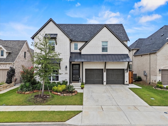 8417 Wembley, The Colony, TX 75056 - view of front of home with brick siding, a front lawn, an attached garage, a standing seam roof, and driveway
