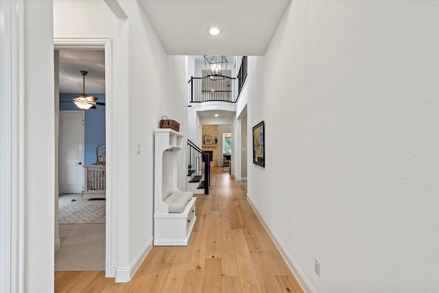 8417 Wembley, The Colony, TX 75056 - hallway with light wood-type flooring, a chandelier, stairs, arched walkways, and recessed lighting