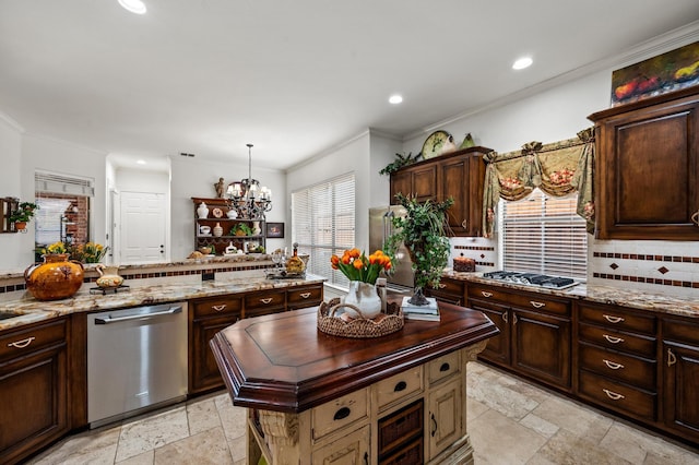 4896 Corinthian Bay Dr, Frisco, TX 75034 - kitchen with appliances with stainless steel finishes, stone tile flooring, backsplash, ornamental molding, and a center island