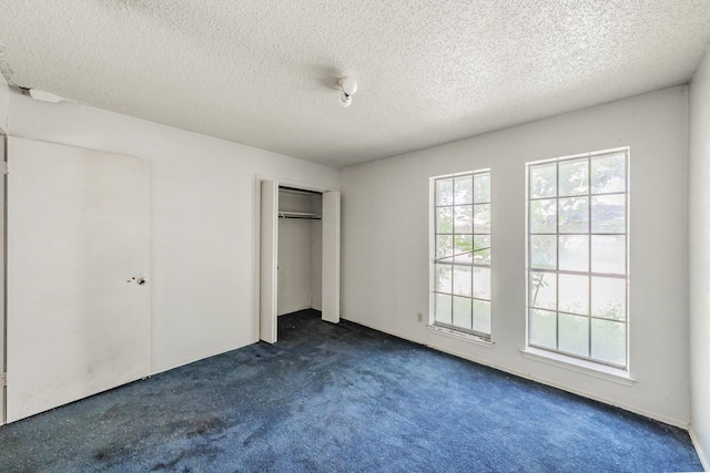 3922 Greenway Dr, Garland, TX 75041 - unfurnished bedroom featuring dark colored carpet, a closet, and a textured ceiling