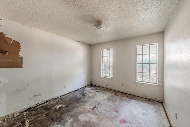 3922 Greenway Dr, Garland, TX 75041 - empty room featuring a textured ceiling and unfinished concrete flooring