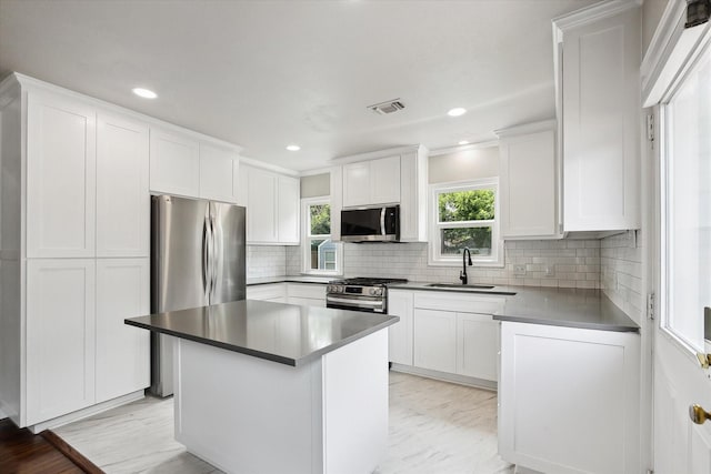 3620 Stadium Dr, Fort Worth, TX 76109 - kitchen with stainless steel appliances, white cabinetry, decorative backsplash, recessed lighting, and a kitchen island