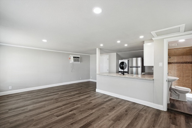 3620 Stadium Dr, Fort Worth, TX 76109 - unfurnished living room featuring stacked washer and clothes dryer, dark wood finished floors, recessed lighting, a wall mounted air conditioner, and crown molding
