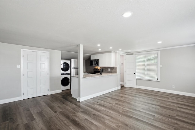 3620 Stadium Dr, Fort Worth, TX 76109 - unfurnished living room featuring estacked washer and dryer, recessed lighting, and dark wood-type flooring