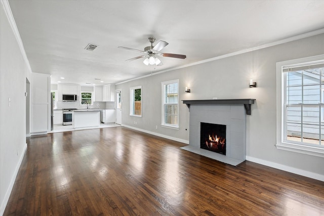 3620 Stadium Dr, Fort Worth, TX 76109 - unfurnished living room featuring a ceiling fan, ornamental molding, a tile fireplace, and dark wood-style floors