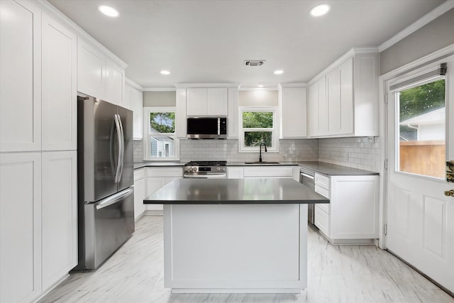3620 Stadium Dr, Fort Worth, TX 76109 - kitchen featuring appliances with stainless steel finishes, plenty of natural light, white cabinetry, ornamental molding, and decorative backsplash