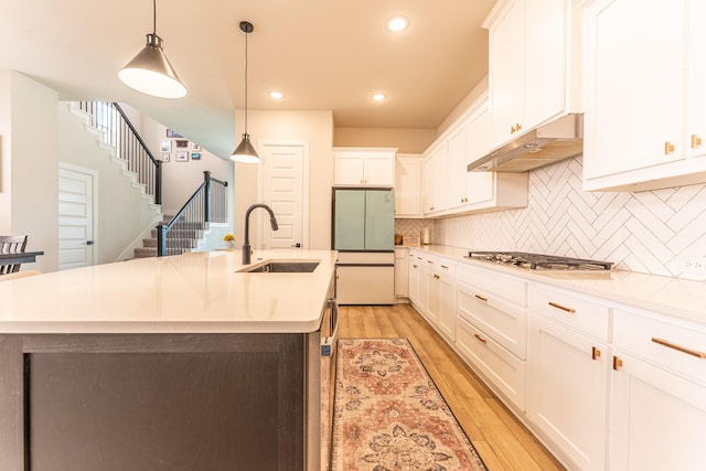 8849 Redding St, North Richland Hills, TX 76180 - kitchen featuring under cabinet range hood, stainless steel gas stovetop, freestanding refrigerator, tasteful backsplash, and white cabinets