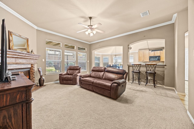 3301 Marymount Dr, Denton, TX 76210 - living room with light colored carpet, arched walkways, a fireplace, a ceiling fan, and crown molding