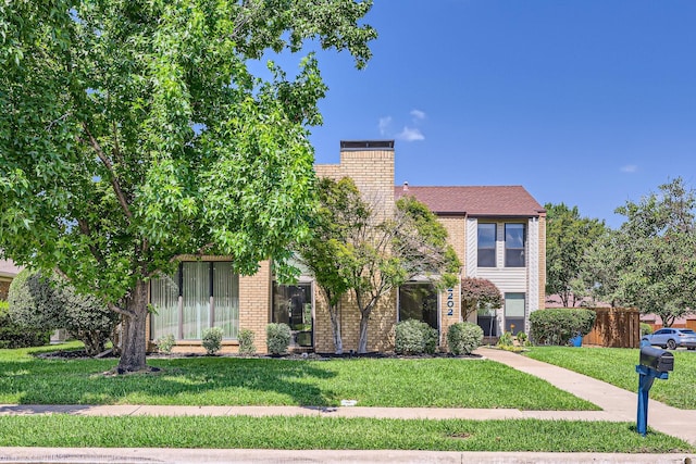 2202 Southern Ct, Carrollton, TX 75006 - view of front of home with a front yard, a chimney, and brick siding