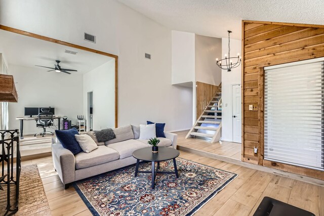 2202 Southern Ct, Carrollton, TX 75006 - living area featuring stairway, a chandelier, light wood finished floors, a ceiling fan, and high vaulted ceiling
