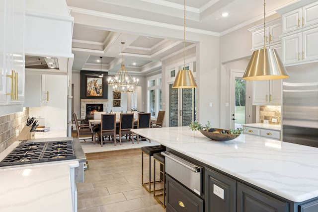 5724 Bellaria Ct, Flower Mound, TX 75022 - kitchen with a warming drawer, white cabinetry, a glass covered fireplace, crown molding, and light stone countertops