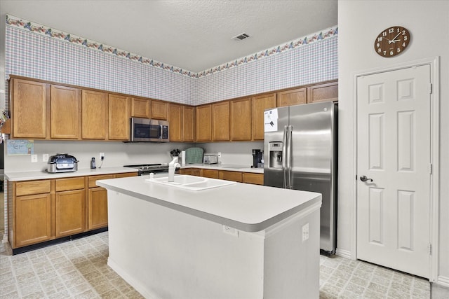 2918 Beau Dr, Mesquite, TX 75181 - kitchen featuring appliances with stainless steel finishes, light countertops, brown cabinets, and a textured ceiling