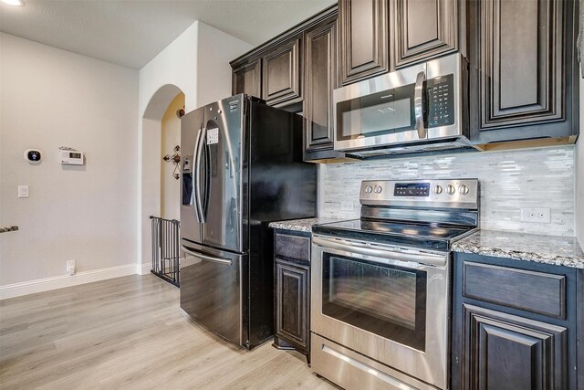 433 Joseph Ln, Crowley, TX 76036 - kitchen featuring appliances with stainless steel finishes, light stone counters, tasteful backsplash, light wood-style floors, and dark brown cabinetry