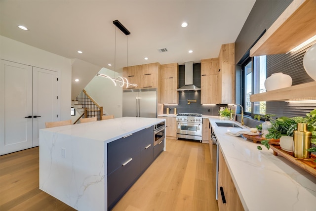 3825 Munger Ave, Dallas, TX 75206 - kitchen featuring modern cabinets, high quality appliances, wall chimney range hood, light wood-style flooring, and tasteful backsplash