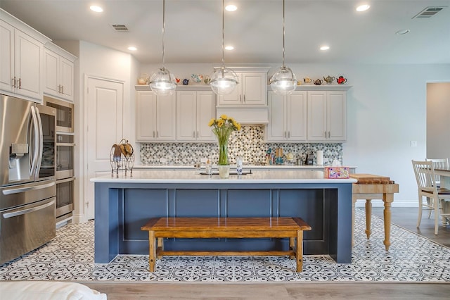 5729 Violet Crown Pl, Fort Worth, TX 76126 - kitchen featuring appliances with stainless steel finishes, backsplash, a kitchen bar, an island with sink, and recessed lighting