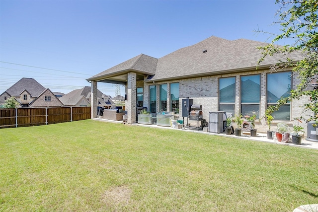 5729 Violet Crown Pl, Fort Worth, TX 76126 - rear view of house featuring a fenced backyard, an outdoor kitchen, brick siding, roof with shingles, and a patio area
