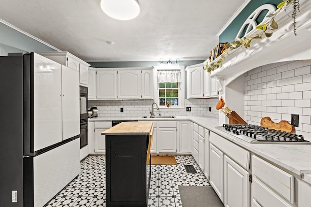 425 W Belden St, Sherman, TX 75092 - kitchen featuring freestanding refrigerator, light floors, white cabinetry, and crown molding