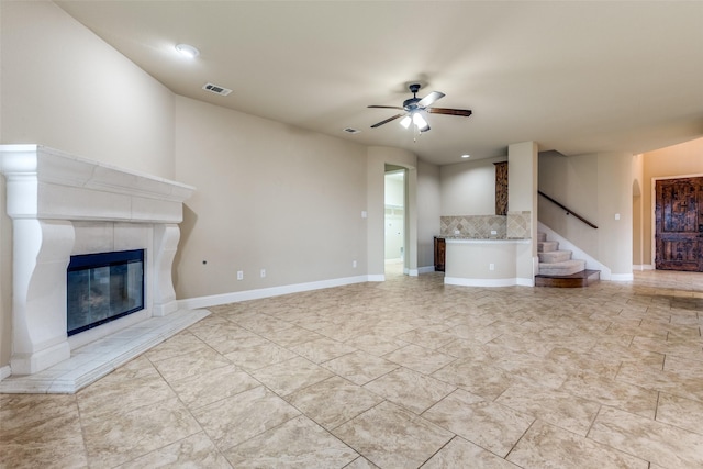 302 Shire Ln, Celina, TX 75009 - unfurnished living room featuring ceiling fan, a tiled fireplace, and stairs