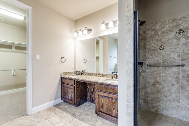 302 Shire Ln, Celina, TX 75009 - bathroom featuring a walk in closet, double vanity, a stall shower, and tile patterned flooring